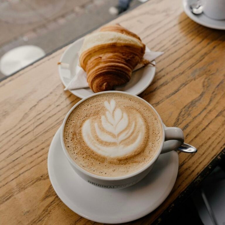 Cappuccino next to a croissant